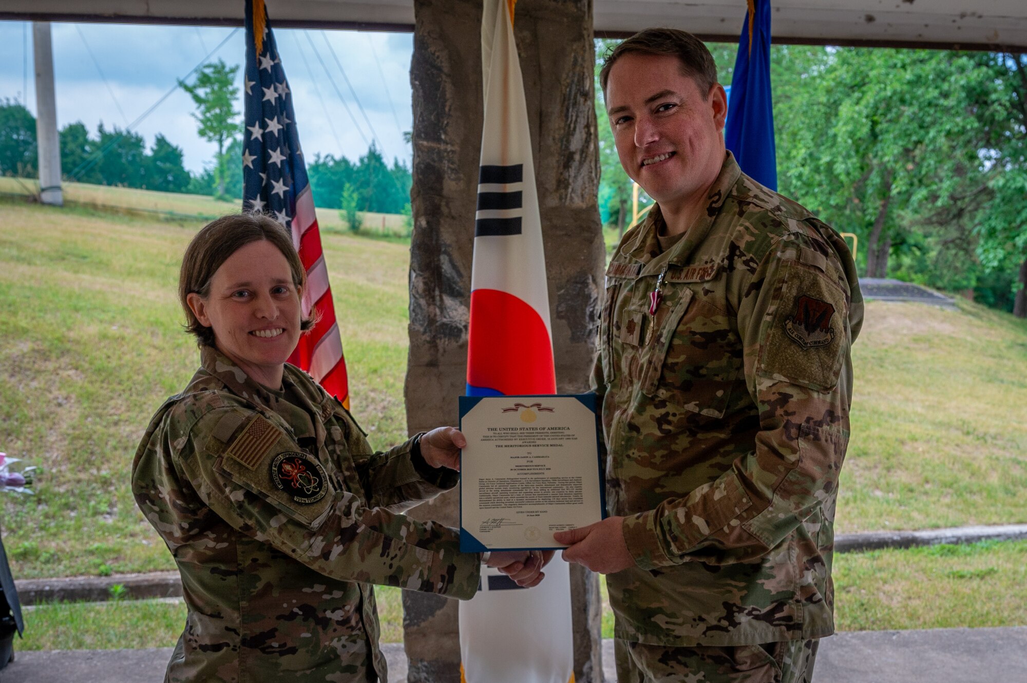 Lt. Col. Sarah Summers, left, 709th Technical Maintenance Squadron commander, poses with Maj. Jason Cammarata, Air Force Technical Applications Center Detachment 403 outgoing commander, after presenting him with a Meritorious Service Medal for his leadership and dedicated time as commander of Det. 403