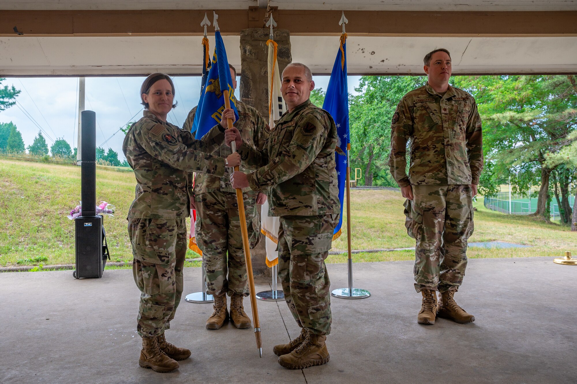 Lt. Col. Sarah Summers, left, 709th Technical Maintenance Squadron commander, presents Maj. Brent Johnson, Air Force Technical Applications Center Detachment (AFTAC, Det) 403 incoming commander, the AFTAC, Det 403 guidon