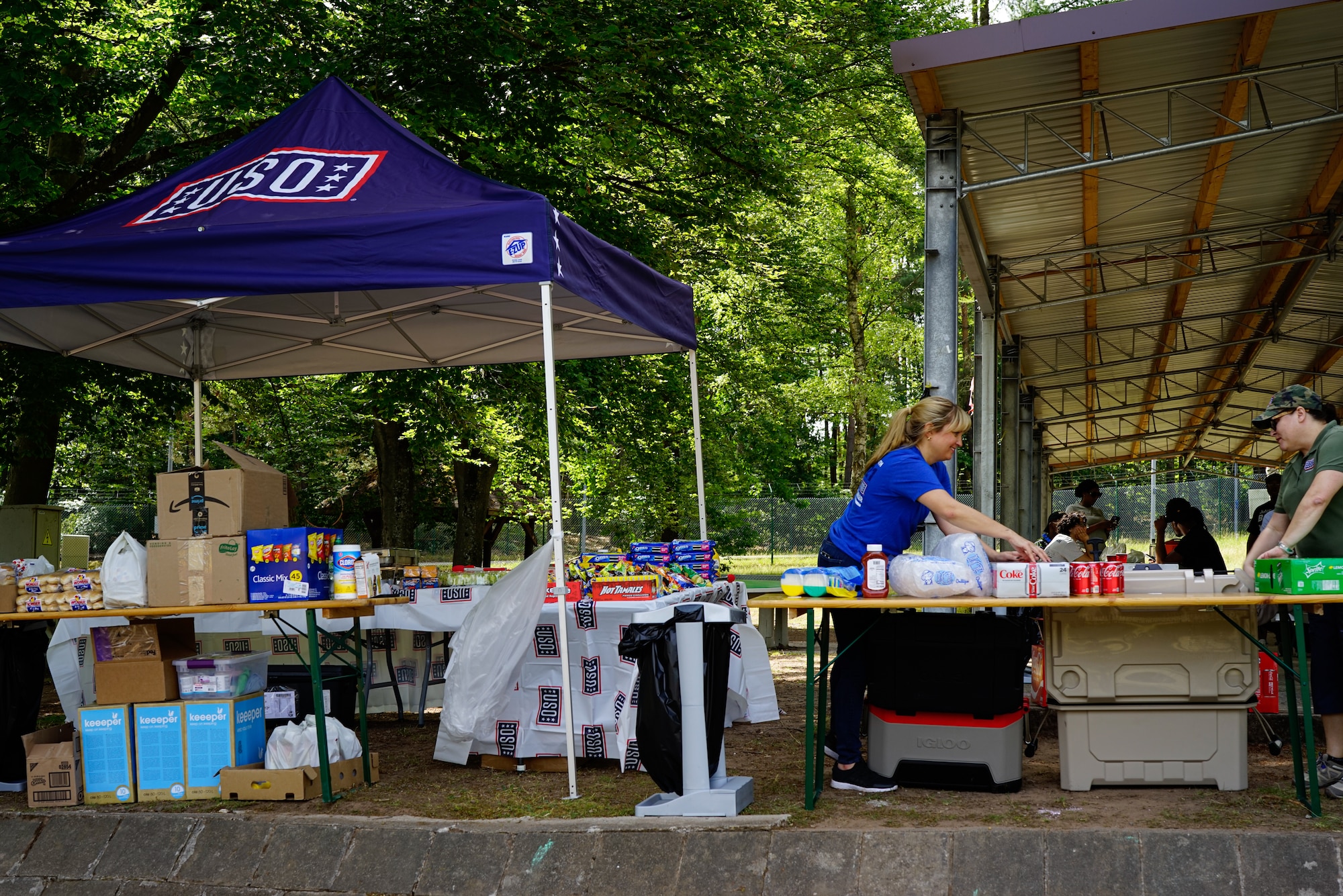 USO volunteers set up a table for the Juneteenth Celebration at Pulaski Barracks, Germany, June 18, 2022. The USO donated drinks, chips, and other side items. The event featured a kid zone, spades tournament, and educational tribute speakers.  (U.S. Air Force photo by Airman 1st Class Lauren Jacoby)