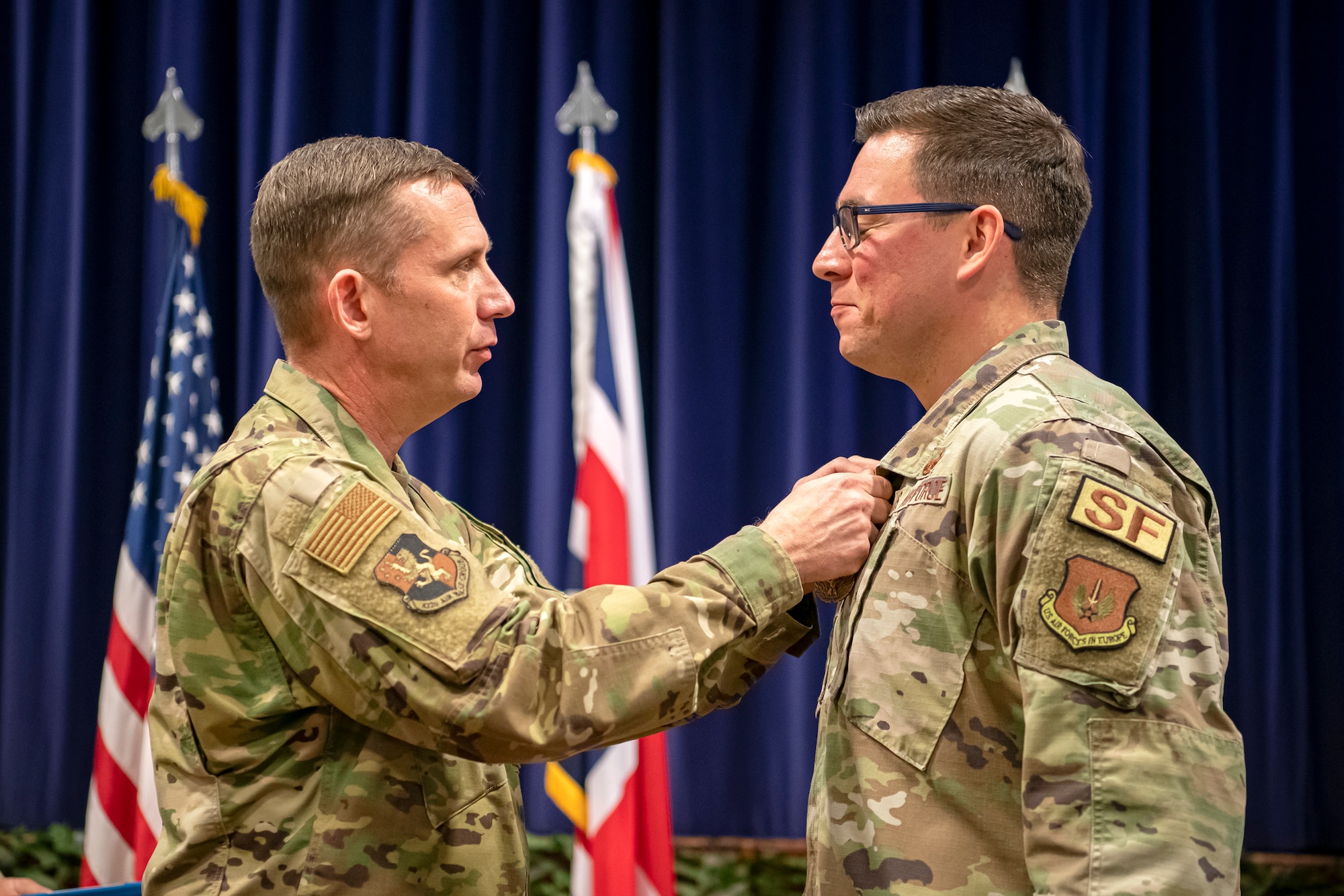 U.S. Air Force Col. Jon T. Hannah, left, 422d Air Base Group commander, pins a meritorious service medal onto Maj. Thomas W. Uhl, 422d Security Forces Squadron commander, during a change of command ceremony at RAF Croughton, England, June 16, 2022. Throughout his command, Uhl led over 200 Defenders, Ministry of Defence Police and Guard along with augmentees in providing security for the U.S. Air Force’s only Bomber Forward Operation location and protection level 1 resources within the United Kingdom. (U.S. Air Force photo by Staff Sgt. Eugene Oliver)