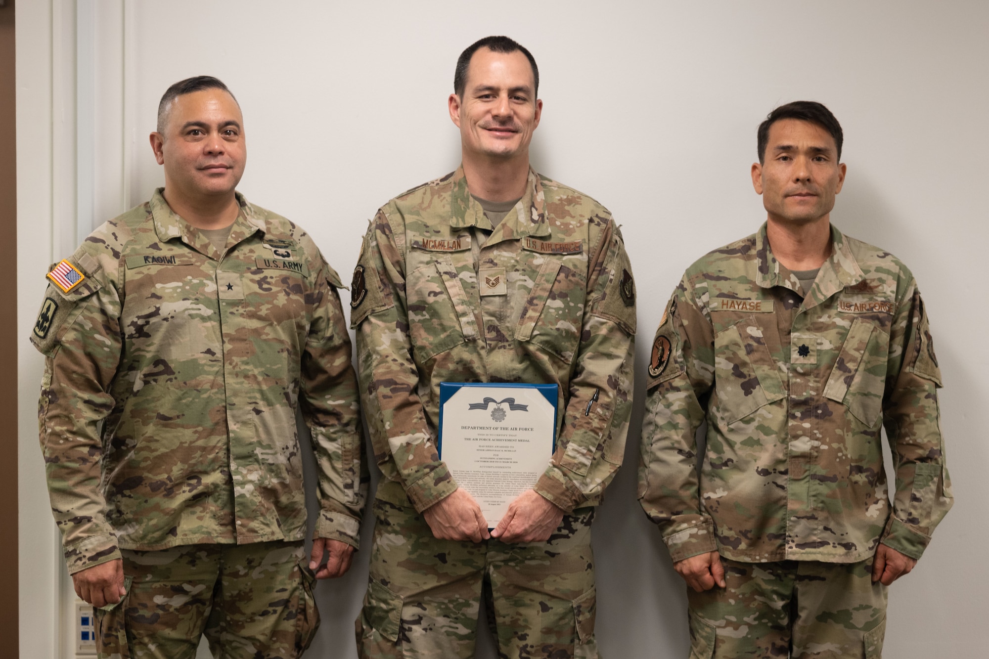 U.S. Air Force Staff Sgt. Isaac McMillan (center) is awarded an achievement medal with U.S. Army Brig. Gen. Moses Kaoiwi Jr., Hawaii Army National Guard commander, and U.S. Air Force Lt. Col. Glen Hayase, for his efforts in standing up the Hawaii National Guard’s first Cyber Mission Assurance Team May 14, 2022, at Fort DeRussy, Hawaii.