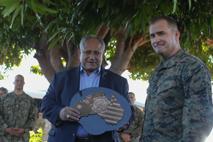 U.S. Marine Corps Col. Christopher Steele, the commanding officer of Marine Rotational Force-Darwin (MRF-D) 22, presents the U.S. Secretary of the Navy Carlos Del Toro a plaque in appreciation for his leadership, during a visit with MRF-D 22 at Royal Australian Air Force Base Darwin, NT, Australia, June 18, 2022. Secretary Del Toro visited Marines and Sailors with MRF-D 22 and Australian Defence Force personnel as part of the Indo-Pacific battlefield circulation. (U.S. Marine Corps photo by Cpl. Emeline Molla)