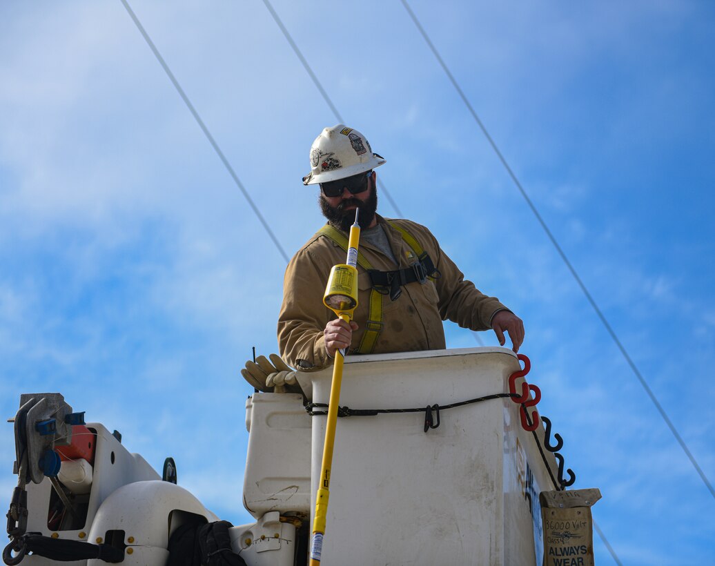 Thomas Donahue, contractor, grabs a “hot stick” from a colleague atop a lift at substation N on Vandenberg Space Force Base, Calif., Jun 2, 2022. Airmen and civilians assigned to the 30th Civil Engineer Squadron, along with contractors, successfully routed power to substation N, re-energizing south loop two. (U.S. Space Force photo by Airman 1st Class Ryan Quijas)