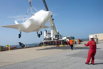 (June 6, 2022) NAVAL AIR STATION PENSACOLA, Fla. -- Personnel from the Naval Air Technical Training Center's air department hold an F-35B Lightning 2 (BF-2) training asset steady as a local crane crew lowers it from the Navy Relentless ship. (U.S. Navy photo)