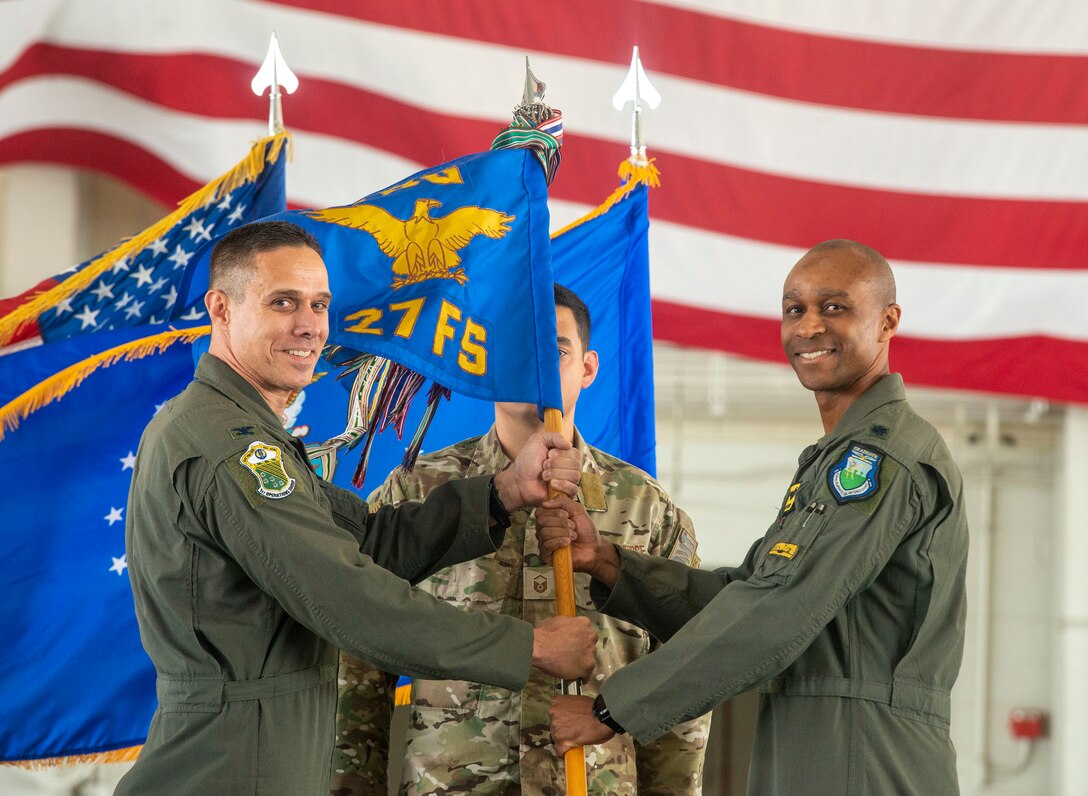 Two Airmen hold a guidon.