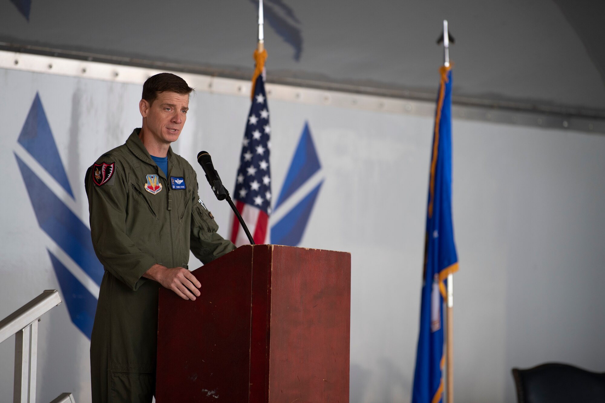 A photo of a man standing on stage in front of a podium.