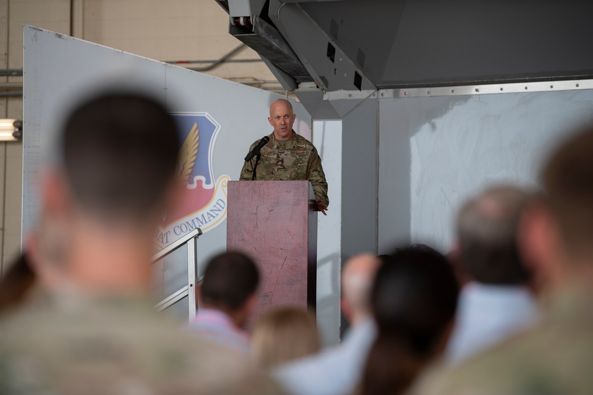 A photo of a man standing on stage in front of a podium.