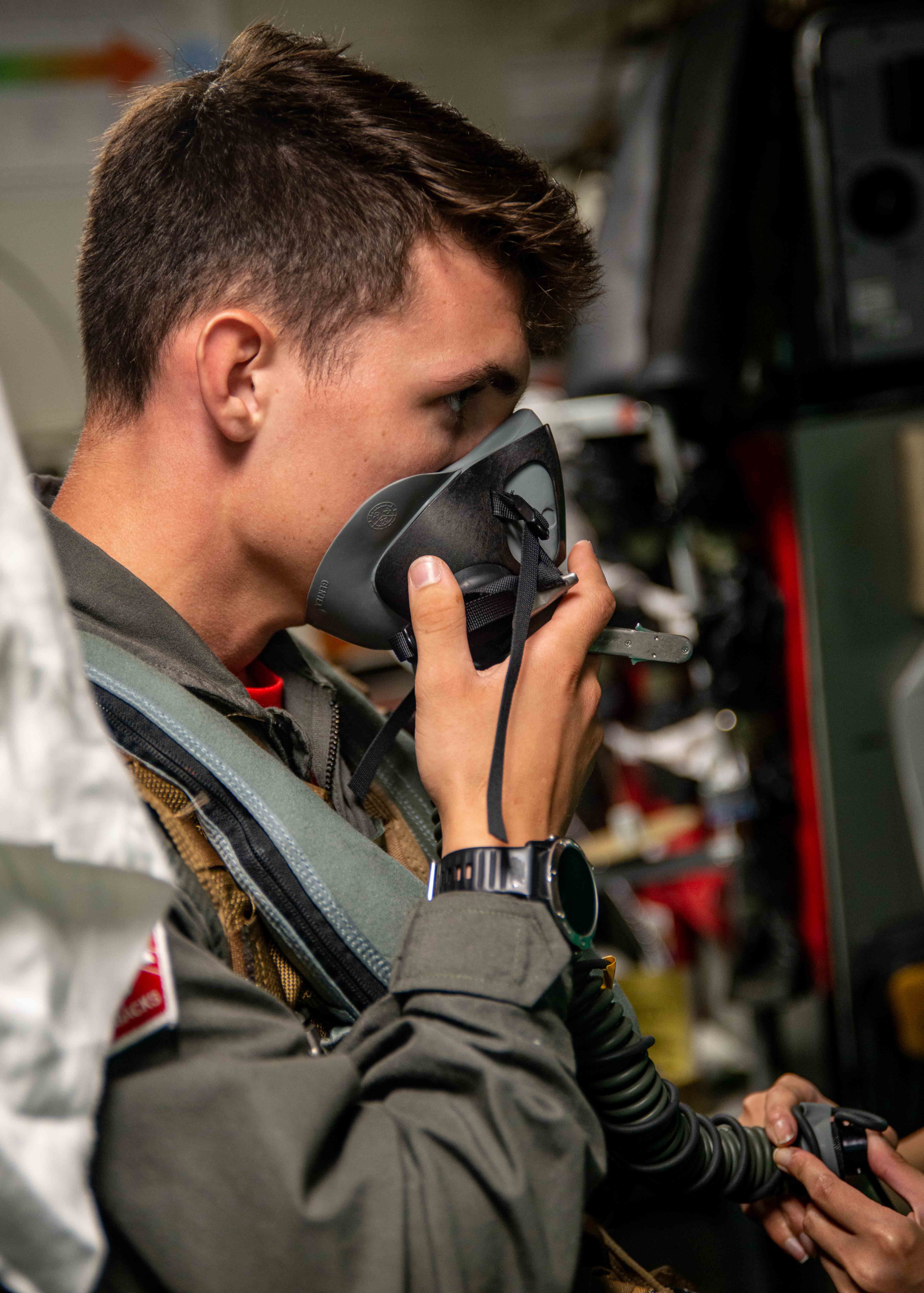 Midshipman 1st Class Nate Williams, from Narragansett, Rhode Island, checks for a tight seal on his oxygen mask in the aircrew survival equipmentman shop for the "Diamondbacks" of Strike Fighter Squadron (VFA) 102 aboard the U.S. Navy's only forward-deployed aircraft carrier USS Ronald Reagan (CVN 76).