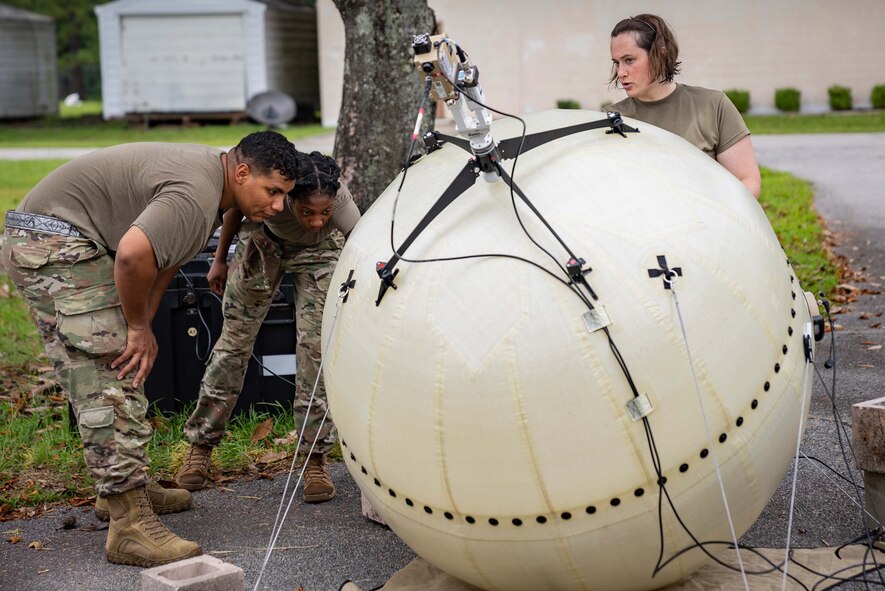 Airmen set up a network antenna.