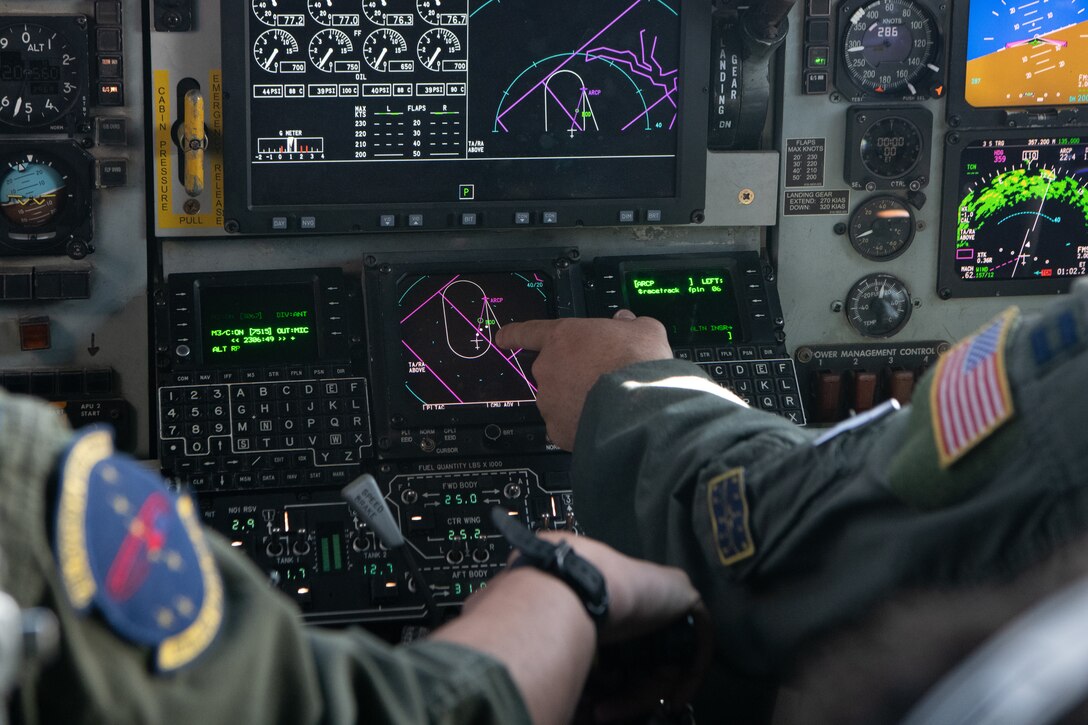 Pilots point at displays in a KC-135.