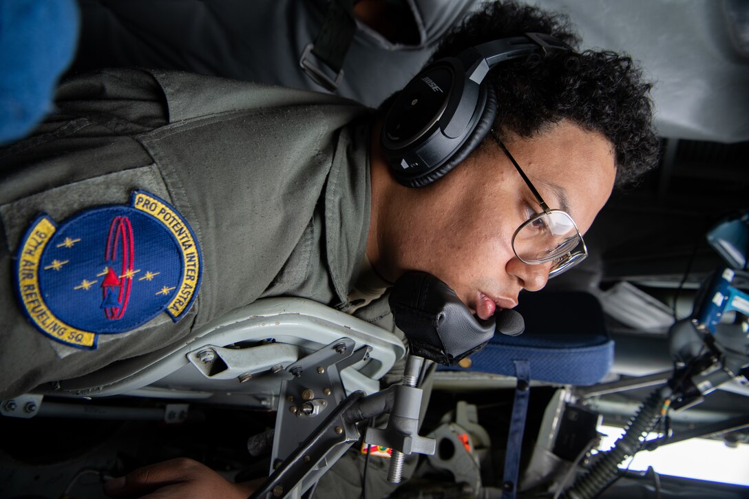 A boom operator lays in the back of a KC-135.