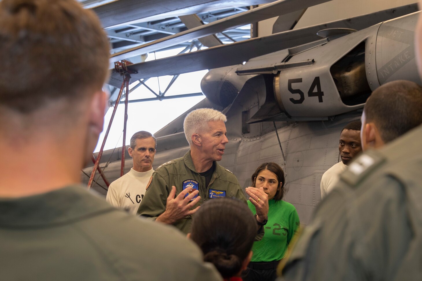 PACIFIC OCEAN (June 16, 2022) – Vice Adm. Karl Thomas, Commander, U.S. 7th Fleet, center, speaks with Sailors assigned to Helicopter Sea Combat Squadron (HSC) 23 in the hangar bay aboard amphibious assault carrier USS Tripoli (LHA 7), June 16, 2022. Tripoli is operating in the U.S. 7th Fleet area of operations to enhance interoperability with allies and partners and serve as a ready response force to defend peace and maintain stability in the Indo-Pacific region.  (U.S. Navy photo by Mass Communication Specialist 1st Class Peter Burghart)