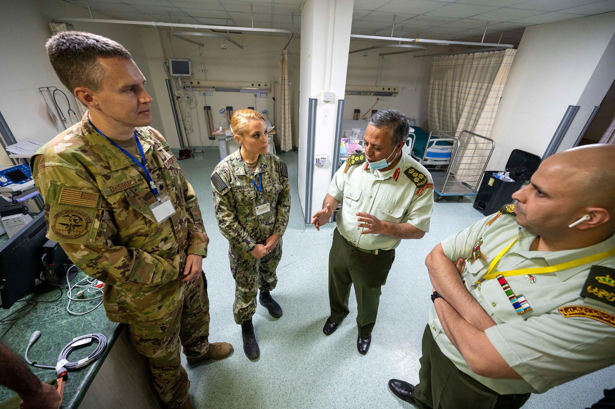 Lt. Col. Erik DeSoucy, Brooke Army Medical Center trauma surgeon and critical care physician, and Lt. Cmdr. Taylor DesRosiers, Walter Reed Medical Center critical care fellow, listen to Dr. Abdullah Alsarhan, Jordanian Royal Medical Service Chief of intensive care unit, discuss post-surgery procedures inside the King Hussein Medical Center May 8, 2022 in Amman, Jordan.