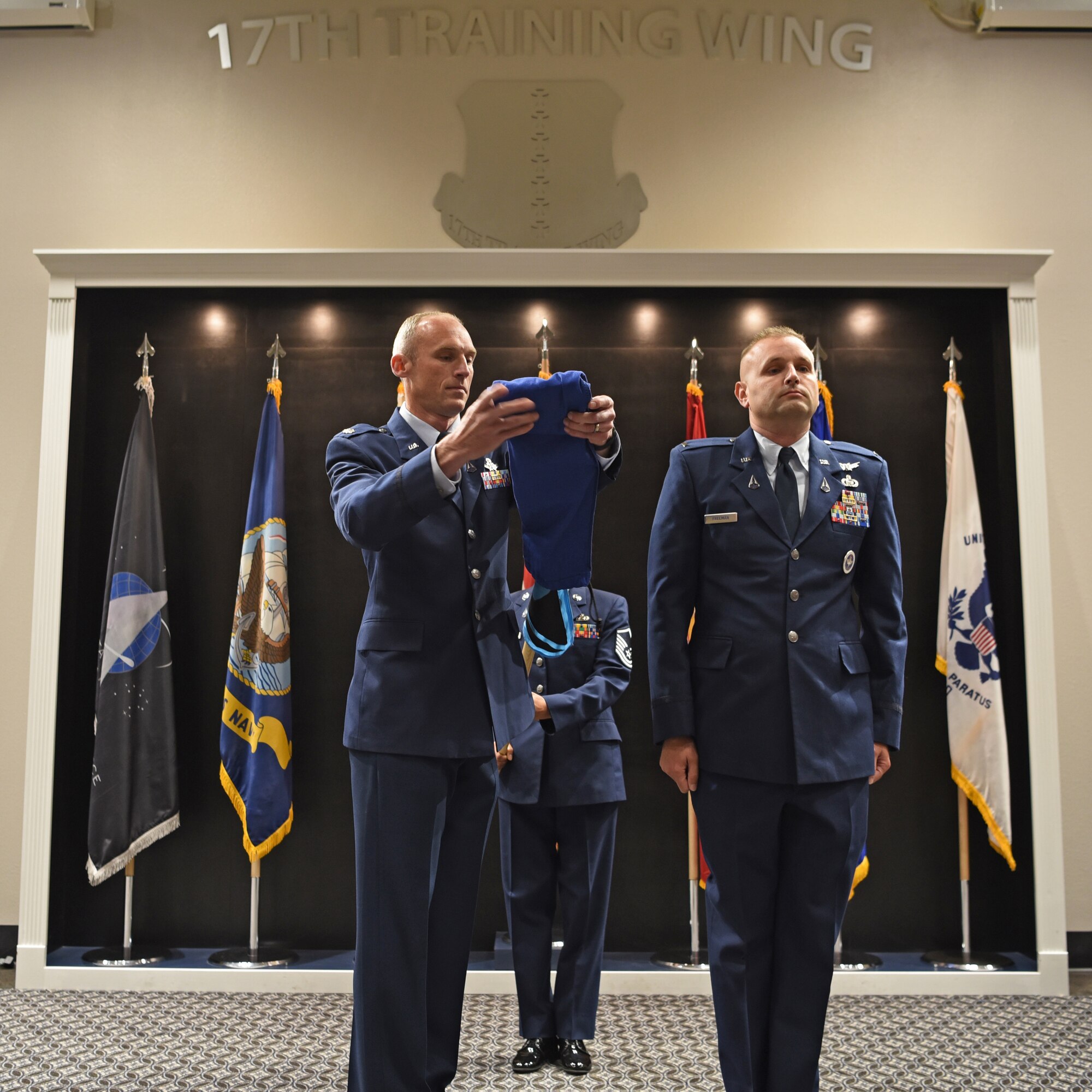 U.S. Space Force Lt. Col. Charles Cooper, 533rd Training Squadron commander, uncases the 533rd TRS guidon during the activation and assumption of responsibility for 533rd TRS, Detachment 1, at the Powell Event Center, Goodfellow Air Force Base, Texas, June 21, 2022. Uncasing the guidon marked the history and lineage beginning for the 533rd TRS, Det 1 on Goodfellow AFB. (U.S. Air Force photo by Senior Airman Abbey Rieves)