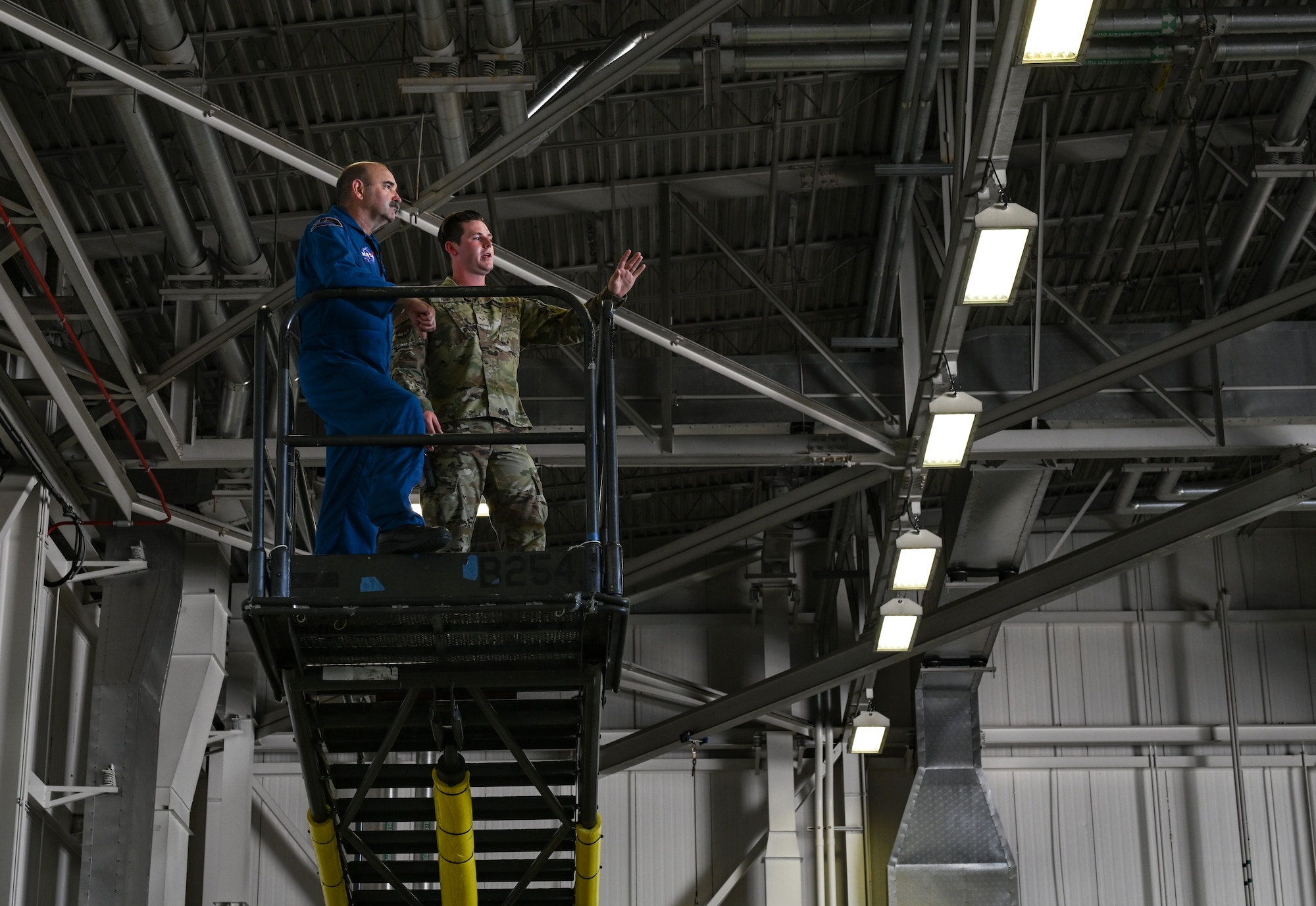 U.S. Air Force Senior Airman Broden Duff, 509th Aircraft Maintenance Squadron crew chief and Tom Parent, NASA Aircraft Operations pilot, look over the B-2 Spirit at Whiteman Air Force Base, Missouri, June 7, 2022. NASA and the 509th Bomb Wing engaged in cross-organizational communication, discussing common mission components between the two organizations. Cross-organizational communication broadens organizations’ scopes and prevents blind spots.