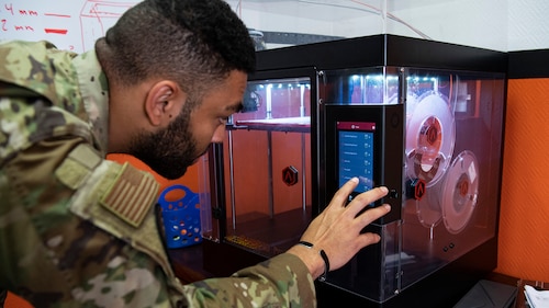 Staff Sgt. Trenton Westfall, 87th Aerial Port Squadron, adjusts a setting on a 3D printer inside one of two innovation labs on Al Udeid Air Base, Qatar. As mission demands allowed, Westfall stepped away from work to initiate a print, often spending more time in the innovation lab on his days off work. The team of three from 87 APS worked together to design, field test, and adjust multiple prototypes in response to real problems experienced by Airmen on the base.
