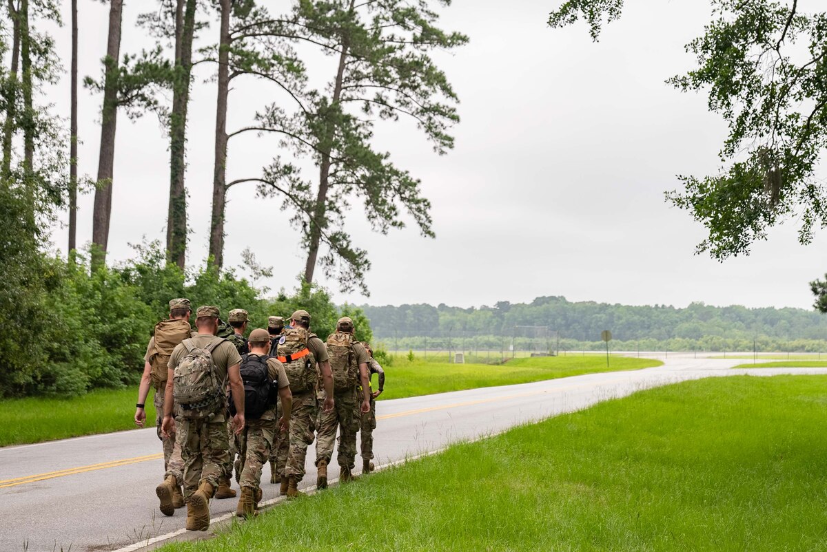 Airmen ruck down a road.