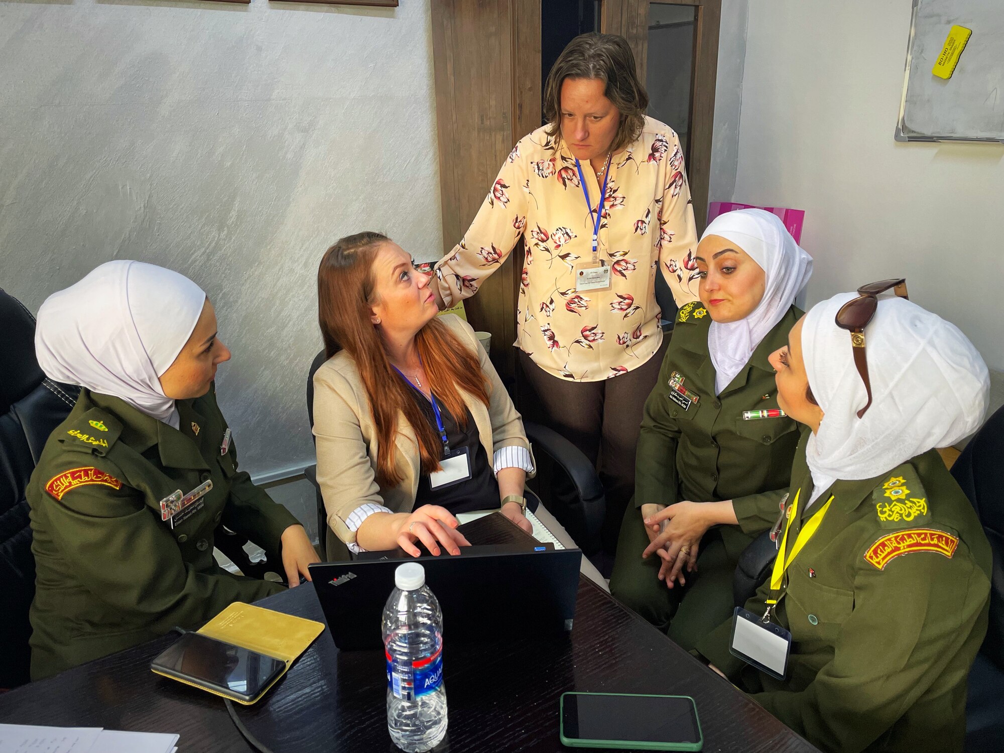 Lt. Col. Dana Mayer, Brooke Army Medical Center trauma nurse clinician, asks a question of Lt. Col. Valerie Sams, Brooke Army Medical Center trauma medical director and clinical team lead for the partner nation trauma exchange, during a conversation about record keeping practices alongside several Jordanian Royal Medical Service nurses inside the King Hussein Medical Center May 11, 2022 in Amman, Jordan.