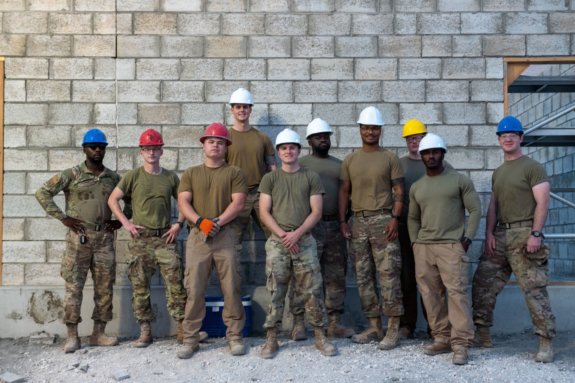 Members of the U.S. Air Force 1st Expeditionary Civil Engineer Group pose for a group photo on a construction site on Al Udeid Air Base, Qatar, June 15, 2022. The group has been constructing a hardened latrine, shower and laundry facility for the past three months. (U.S. Air National Guard photo by Airman 1st Class Constantine Bambakidis)