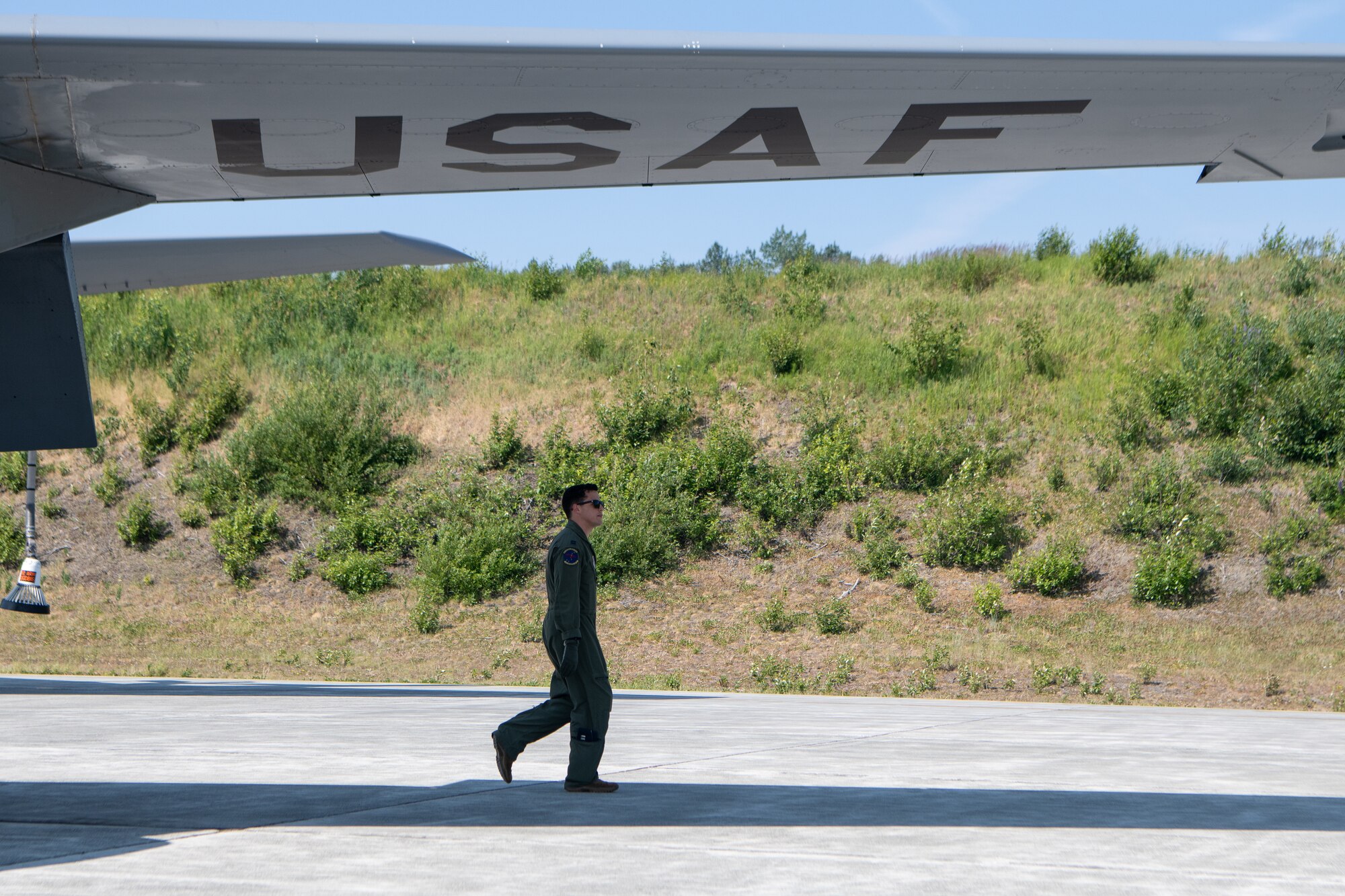 An Airman walks beneath the wing of a KC-135.