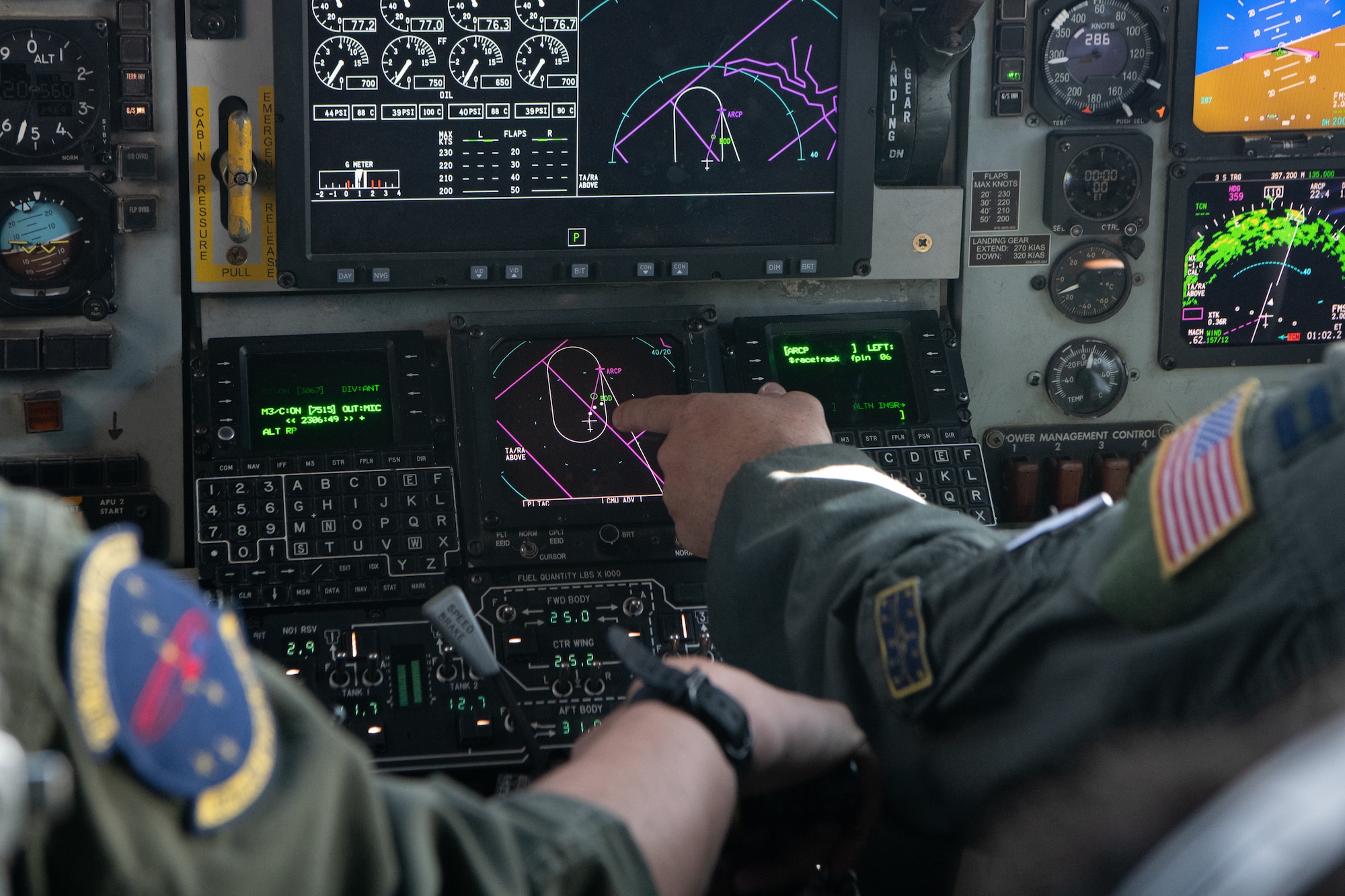 Pilots point at displays in a KC-135.