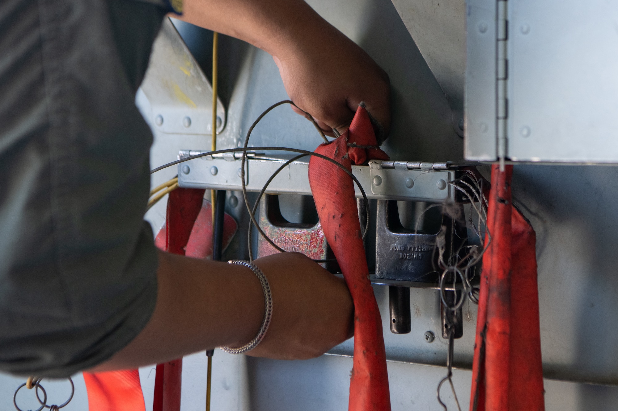 An Airman tightens down straps during pre flight checks.