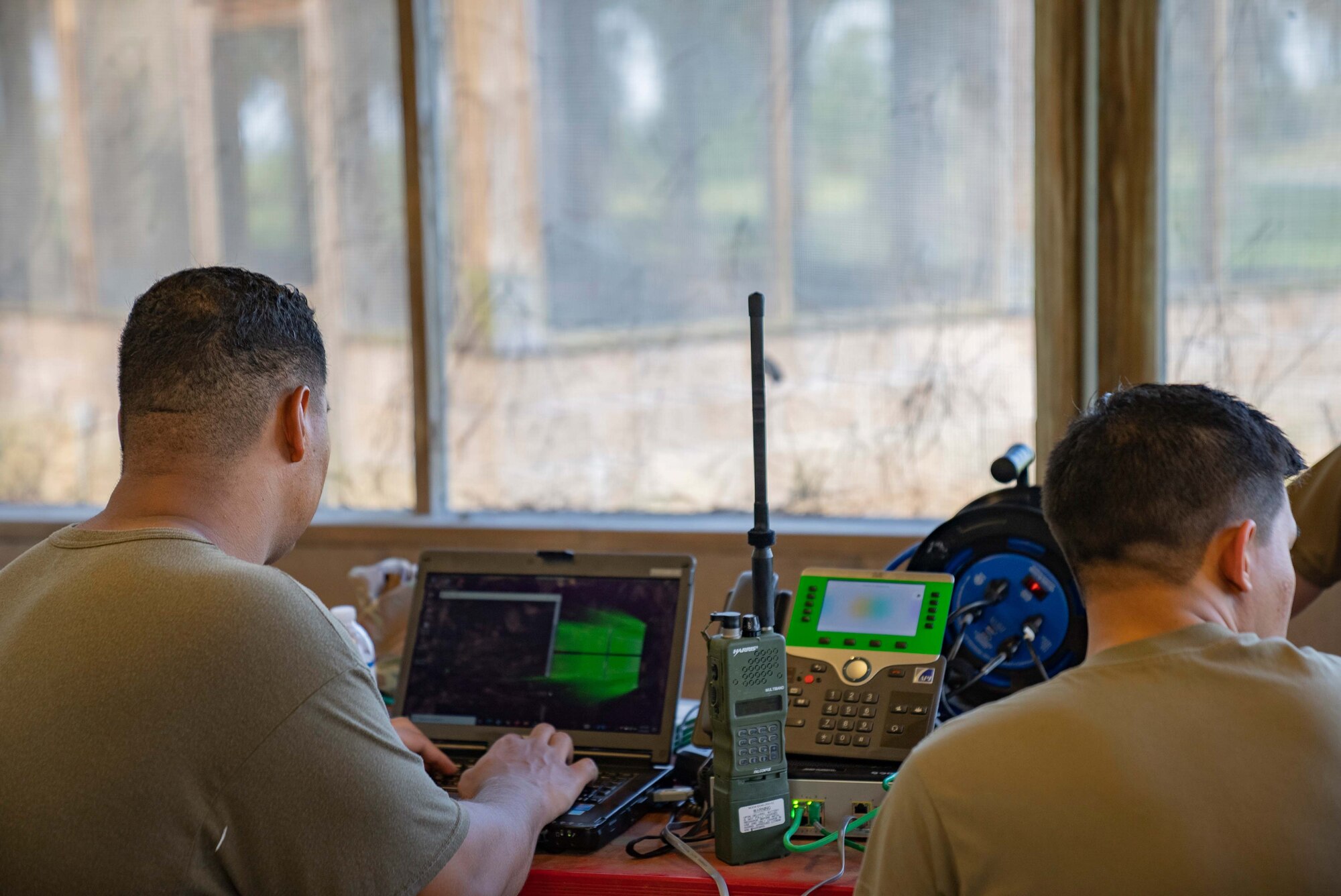 Airmen work at a communications network operating station.