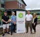 Four people stand outdoors posing for a photo next to a banner that says “Leadership Pocono.”