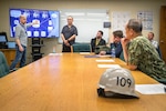 Rear Adm. Huan Nguyen, deputy commander for Cyber Engineering, Naval Sea Systems Command (NAVSEA) receives a briefing on the latest technology innovations May 19, 2022, at Puget Sound Naval Shipyard & Intermediate Maintenance Facility in Bremerton, Washington. (U.S. Navy photo by Scott Hansen)