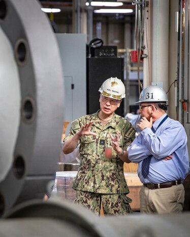 Rear Adm. Huan Nguyen, left, deputy commander for Cyber Engineering, Naval Sea Systems Command, and IT Pillar lead, tours facilities with Dan Arnall, trade superintendent, Shop 31, Machinists, Electroplaters & Toolmakers, May 19, 2022, at Puget Sound Naval Shipyard & Intermediate Maintenance Facility, in Bremerton, Washington. (U.S. Navy photo by Scott Hansen)