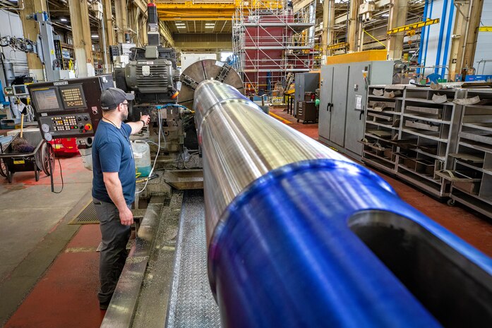 Noah Cemper, machinist, Shop 31, Machinists, Electroplaters & Toolmakers, mills the port rudder shaft from USS Theodore Roosevelt (CVN 71) May 13, 2022, at Puget Sound Naval Shipyard & Intermediate Maintenance Facility in Bremerton, Washington. (U.S. Navy photo by Scott Hansen)