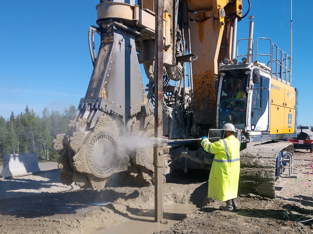 The two machines atop the Moose Creek Dam, a cutter soil mixer and an auger, are being used to mix the existing gravel inside the structure with cement and bentonite to depths of up to 65 feet.