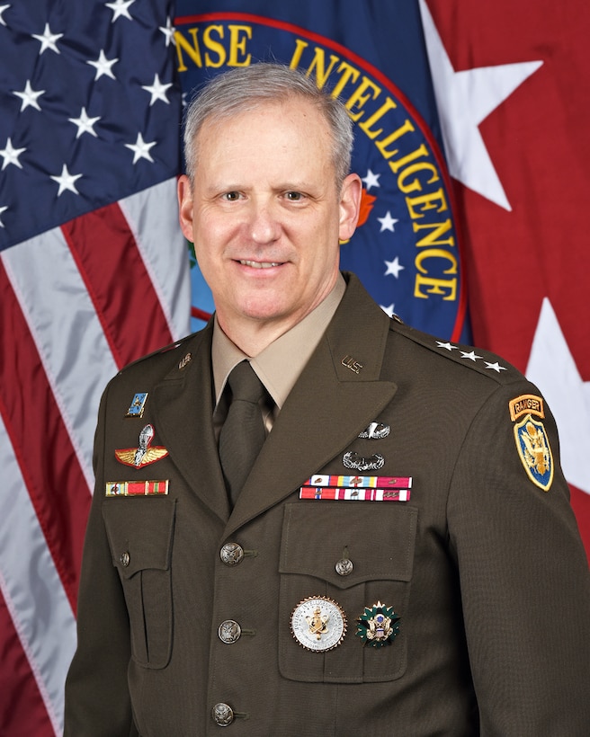 Image portrait of DIA's Director. A military-dress man in front of two flags.