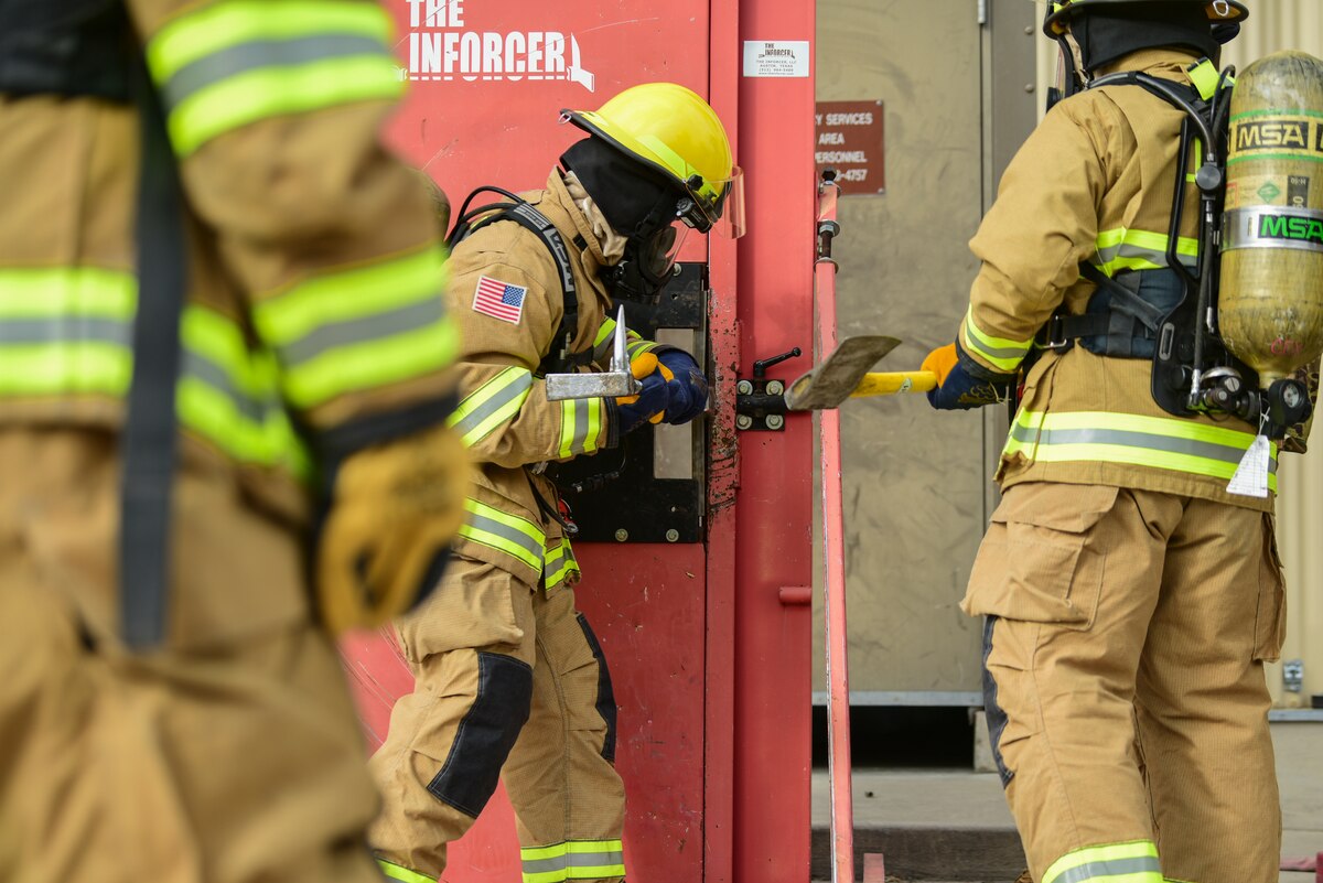 A photo of an firefighter opening a door