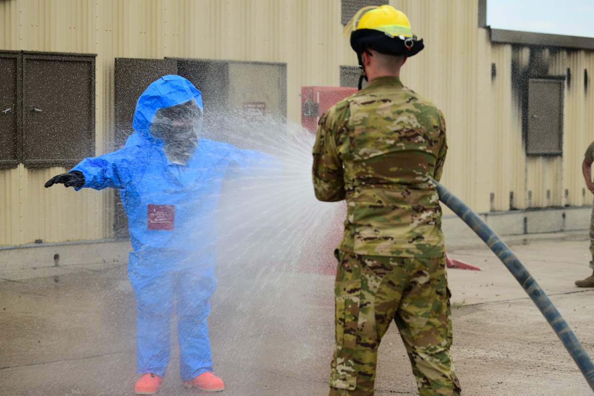 A photo of an Airman getting sprayed with a fire hose
