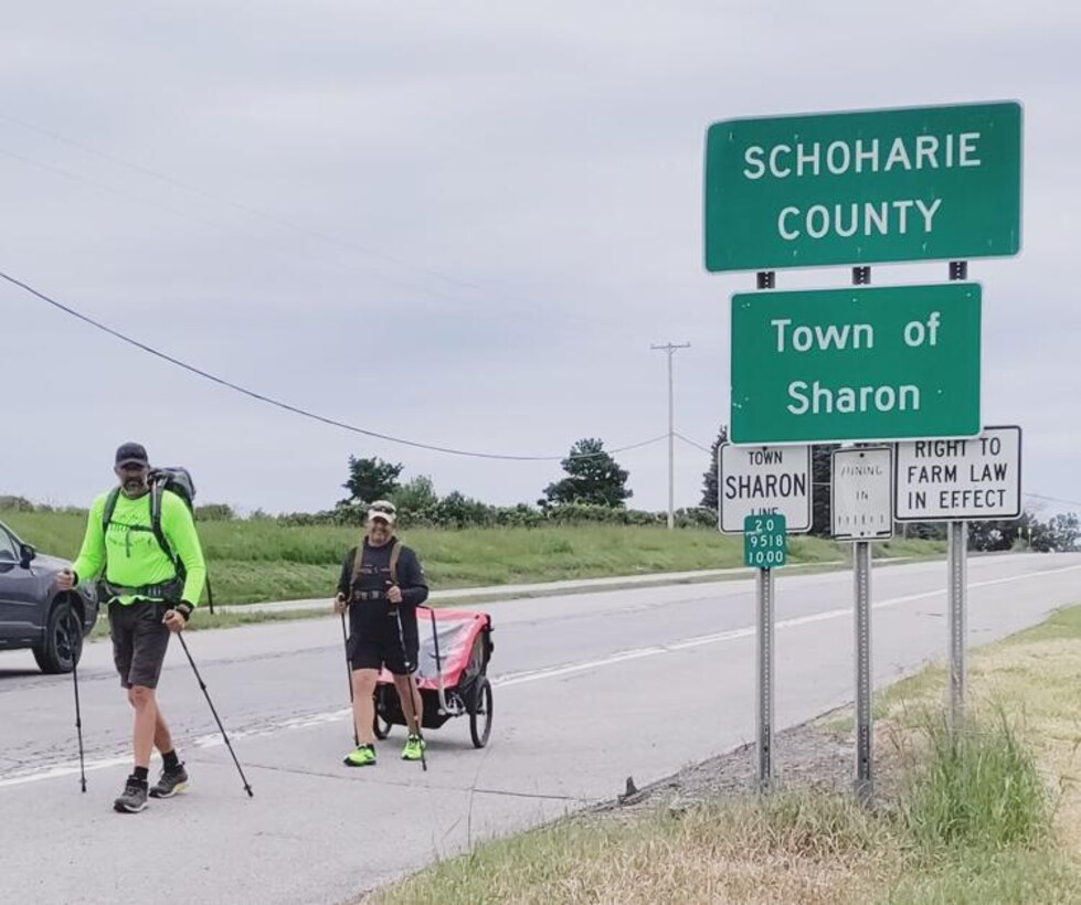 Coleman Kinzer (left) and Justin LeHew lug their gear along U.S. Route 20 as they step into Otsego County after leaving Schoharie County, and head west to raise public awareness about American soldiers missing in action from wars and conflicts.