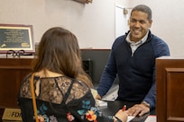 U.S. Army Capt. Pablo Mendez Adorno, Training with Industry banking officer student, helps out a customer at the Armed Forces Bank in at Fort Leavenworth, Kan., March 23, 2022. The year-long TWI banking course trains one banking officer and one noncommissioned officer each year, but with a need to train more finance and comptroller Soldiers in banking operations, the U.S. Army Financial Management Command created a new banking short course to train up to 18 Soldiers per year. (U.S. Army photo by Mark R. W. Orders-Woempner)