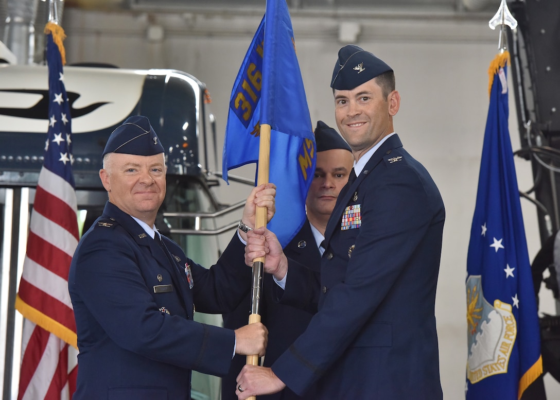 Col. Nate Somers, right, accepts command of the 316th Mission Support Group from Col. Tyler Schaff, 316th Wing and Joint Base Andrews installation commander, during a change of command ceremony at Joint Base Andrews, Md., June 22, 2022.