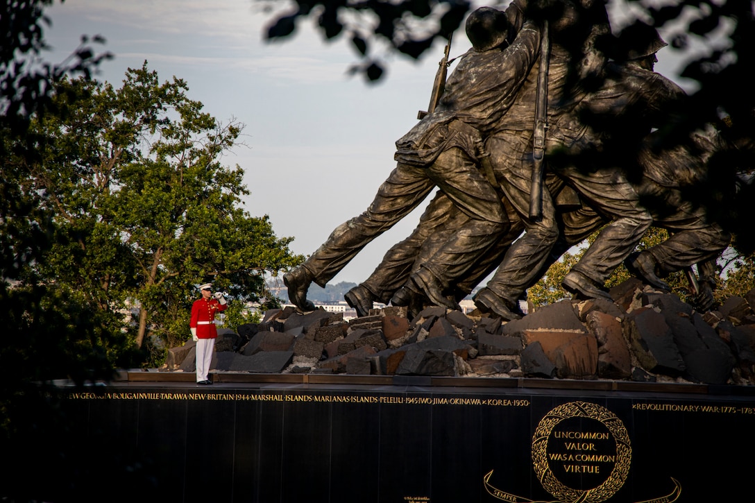 Staff Sgt. Benjamin Aird, ceremonial bugler, “The Commandant’s Own,” U.S. Marine Drum and Bugle Corps, plays “Taps”  during a Sunset Parade at the Marine Corps War Memorial, Arlington, Va., June 21, 2022.