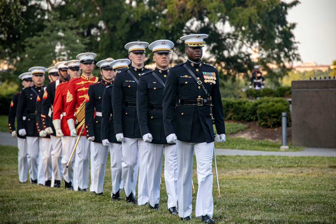 Barracks Marines march down the field after a Sunset Parade at the Marine Corps War Memorial, Arlington, Va., June 21, 2022.