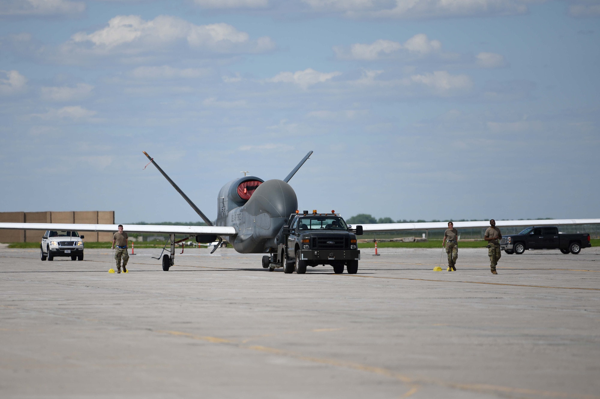 Airmen assigned to the 319th Aircraft Maintenance Squadron from Grand Forks Air Force Base, North Dakota, tow an RQ-4 Block 30 Global Hawk remotely piloted aircraft June 6, 2022, across the Grand Forks Air Force Base flight line to Northrop Grumman at Grand Sky. The RQ-4 Block 30 divestment is a part of the U.S. Air Force’s plan to restructure intelligence, surveillance and reconnaissance to meet national defense priorities and support joint all-domain command and control capabilities. Located on Grand Forks Air Force Base, Grand Sky is a business and aviation park focused on developing and growing the unmanned aerial systems industry. (U.S. Air Force photo by Senior Airman Ashley Richards)