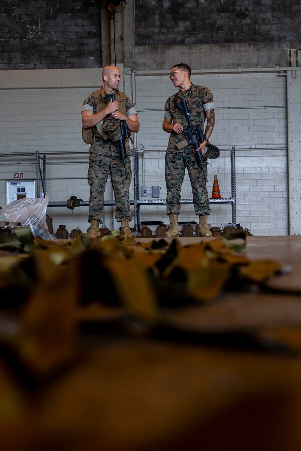U.S. Marine Corps Gunnery Sgt. Roberlan Padilla, a distribution operations chief with Combat Logistics Regiment 37 (CLR-37), 3rd Marine Logistics Group (3rd MLG), left, and Cpl. Thomas Malik, a finance technician with CLR-37, 3rd MLG, right, serve as armed escorts during an Alert Contingency Marine (ACM) drill on Marine Corps Air Station Futenma, Okinawa, Japan, June 8, 2022. Marines and sailors with 3rd MLG, 1st Marine Air Wing, 3d Marine Division supported the ACM drill, which showcased the 3d Marine Expeditionary Brigade’s readiness and validated its ability to rapidly activate and deploy a Forward Command Element. (U.S. Marine Corps photos by Cpl. Francesca Landis)