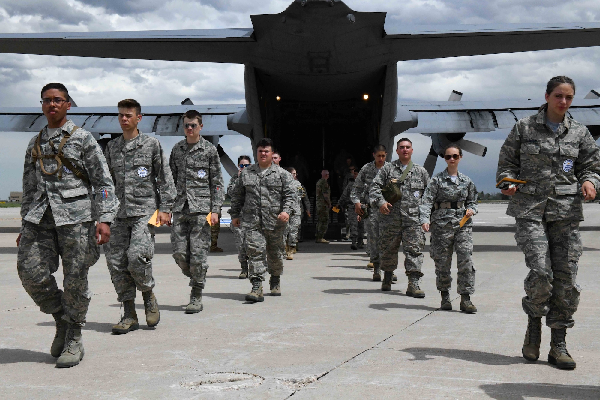 Army and Air Force Junior ROTC Cadets egress a C-130 Hercules at Cheyenne Regional Airport, Cheyenne, Wyoming June 9, 2022. Cadets were led by Wyoming Air National Guardsmen from the aircraft after a flight above Cheyenne. (U.S. Air Force photo by Airman 1st Class Landon Gunsauls)