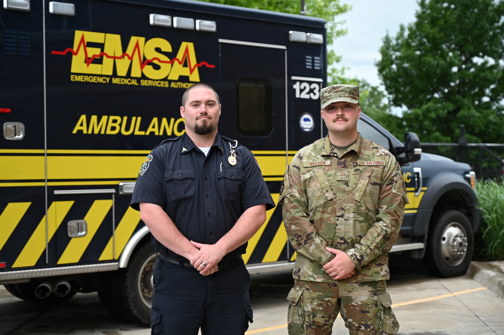 Airman and paramedic stand in front of ambulance