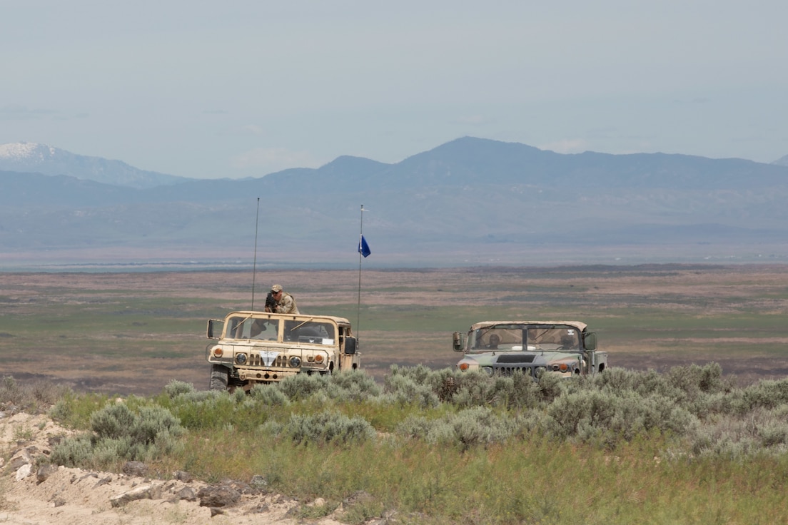 An observer controller/trainer, and opposing forces roleplayers watch as forward observers load into UH-60 Helicopters as they begin a training mission during Western Strike 22, June 9, 2022