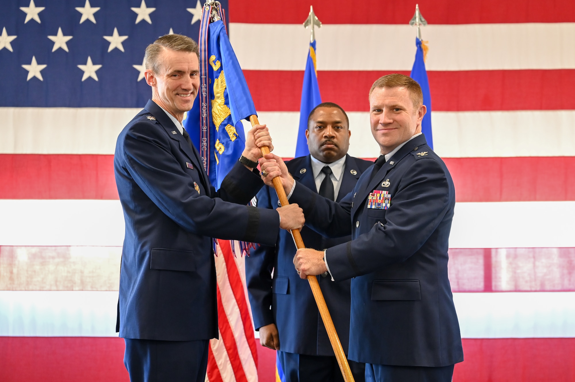 Col. Jeffrey G. Holland, incoming 75th Air Base Wing commander, receives the guidon from Lt. Gen. Tom D. Miller, Air Force Sustainment Center commander, during a change of command ceremony June 22, 2022, at Hill Air Force Base,