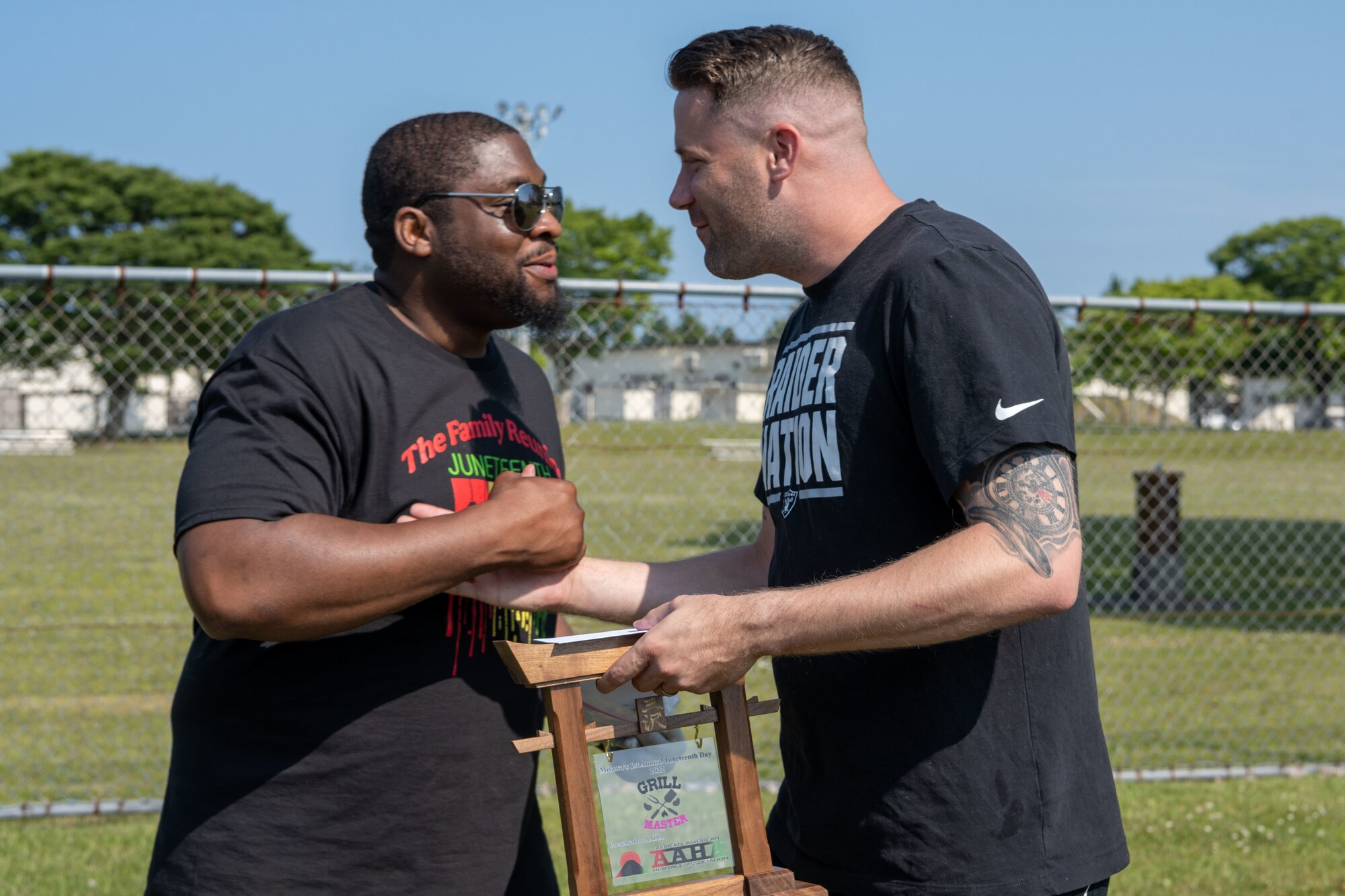 Mr. Shy Jackson, left, 35th Communications Squadron member, congratulates the winner of the grill masters competition, Master Sgt. Joseph Ross, right, 35th Medical Support Squadron member, during the Juneteenth Family Reunion event at Misawa Air Base, Japan, June 18, 2022.