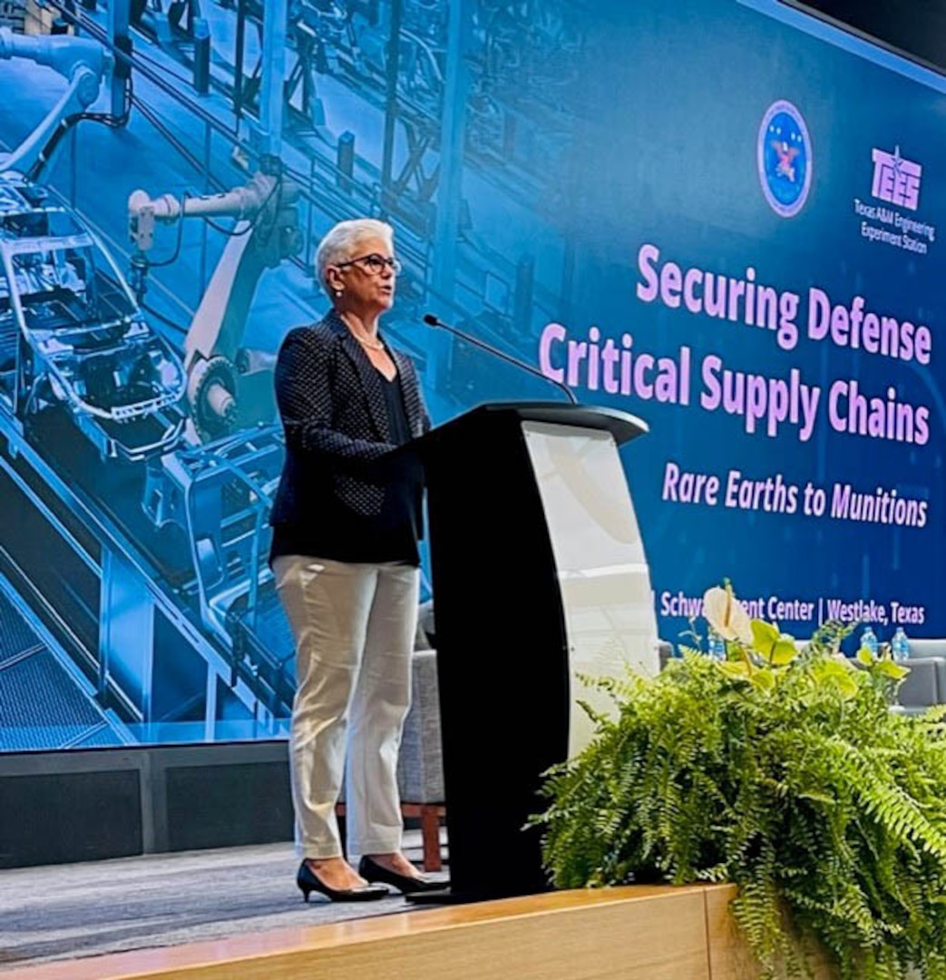 A woman stands behind a lectern.