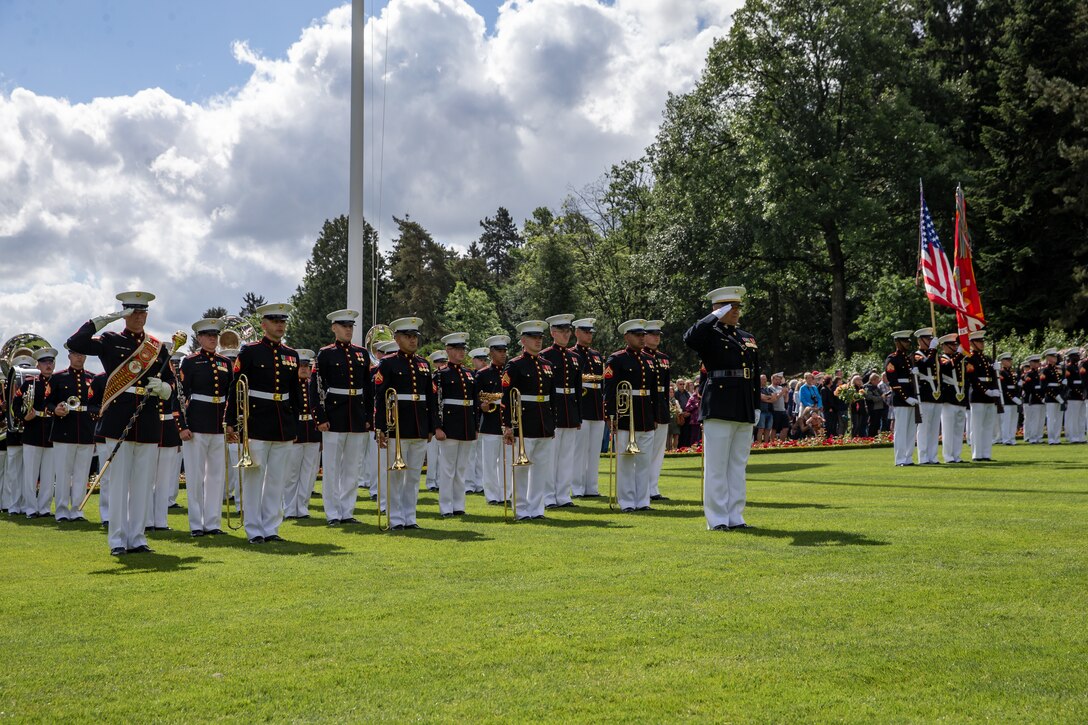 U.S. Marines with the 2nd Marine Division band salute during a ceremony at Aisne-Marne American Cemetery, Belleau, France, May 29, 2022. This Memorial Day ceremony was held to commemorate the 104th anniversary of the Battle of Belleau Wood. The visit is to honor those who made the ultimate sacrifice for their respective countries during World War I. (U.S. Marine Corps photo by Cpl. Jennifer E. Reyes)