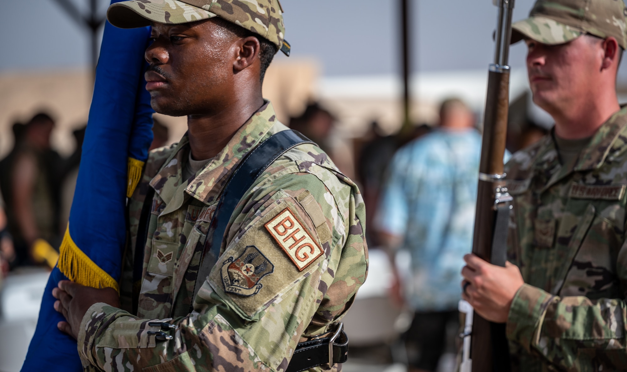 Senior Airman Chadrick Holliday and Airman First Class Aron Burt, 332d Base Honor Guard, exit after presenting the colors during a ceremony at an undisclosed location in Southwest Asia, May 27, 2022. The Honor Guard provides military ceremonial support and dignified transfer support when called upon. (U.S. Air Force photo by Master Sgt. Christopher Parr)